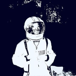 A monochrome picture of Julian in a spacesuit. The image is white on a navy blue background.