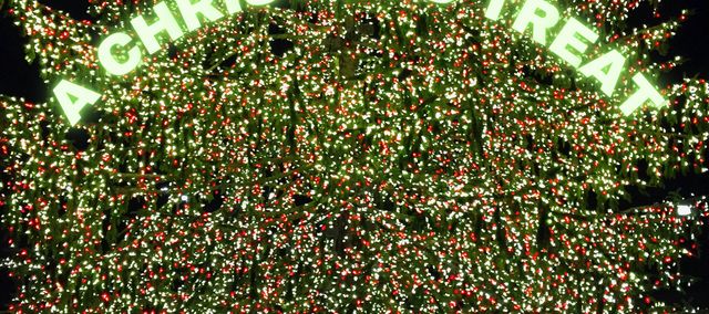 Two sillouttes against a brightly lit Christmas tree