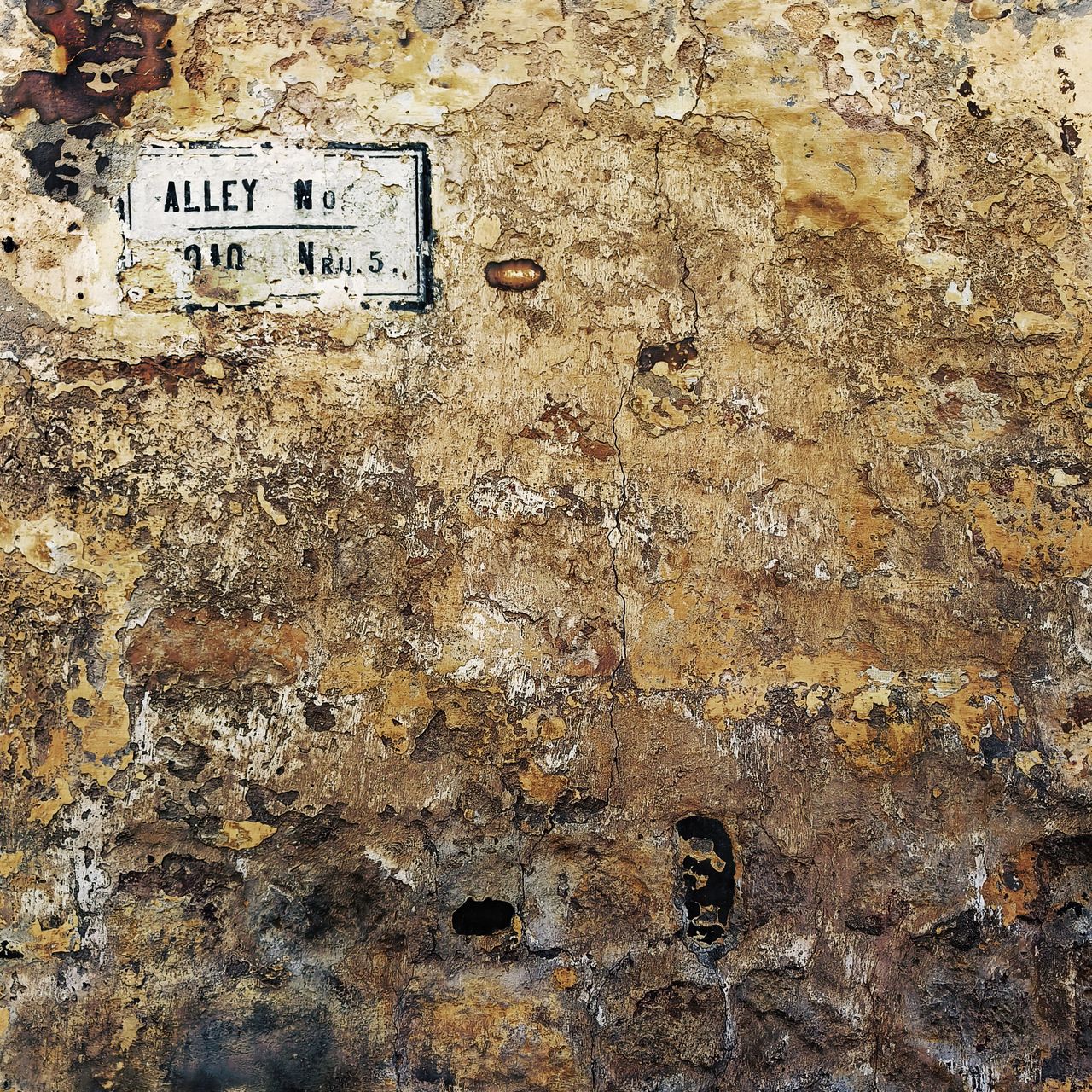 a wall with many layers of peeling brown paint